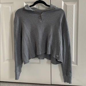 a grey knitted quarter-zipped long sleeve